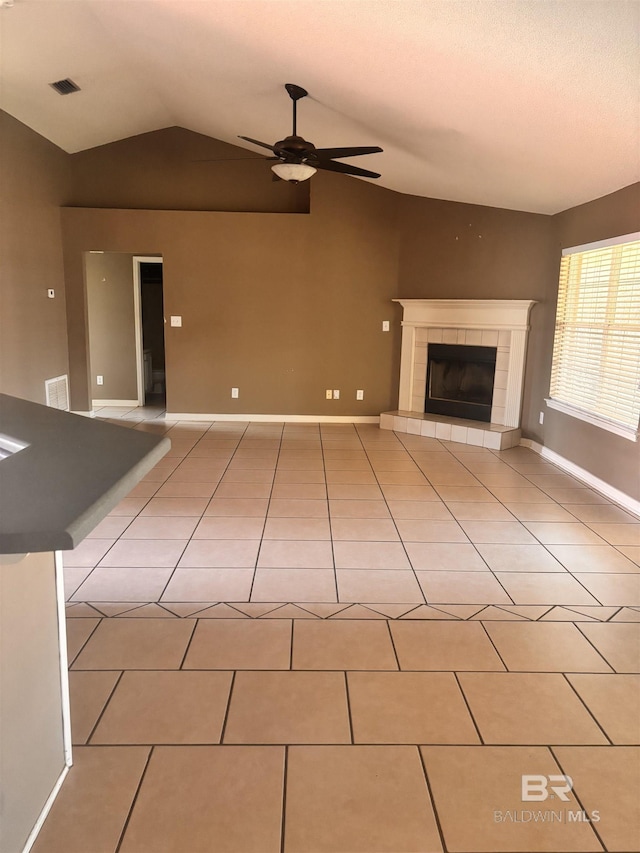 unfurnished living room with light tile patterned floors, visible vents, vaulted ceiling, and ceiling fan