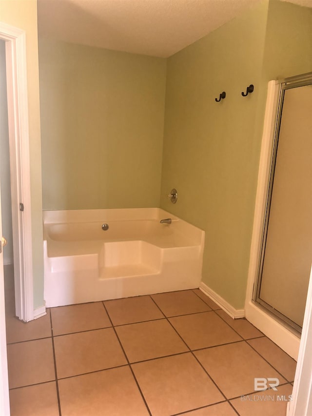 bathroom featuring a bath, tile patterned floors, and a stall shower