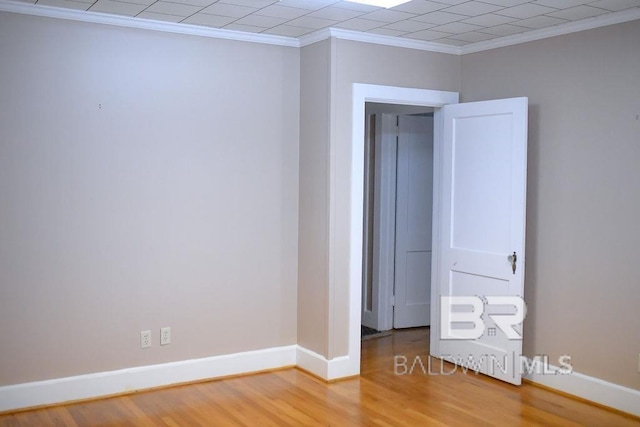 empty room featuring hardwood / wood-style flooring and crown molding