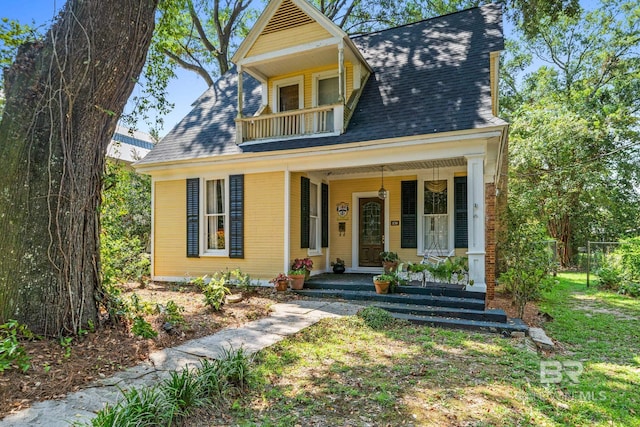 view of front of property with covered porch and a balcony