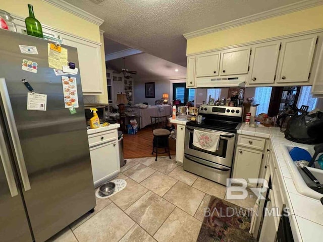 kitchen featuring tile countertops, light tile patterned flooring, crown molding, and appliances with stainless steel finishes