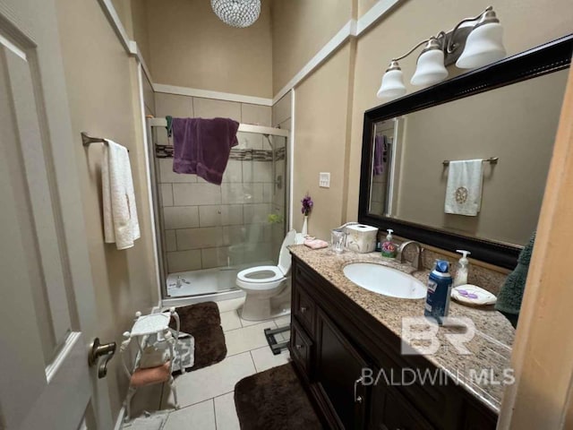 bathroom with tile patterned flooring, vanity, toilet, and a shower with shower door