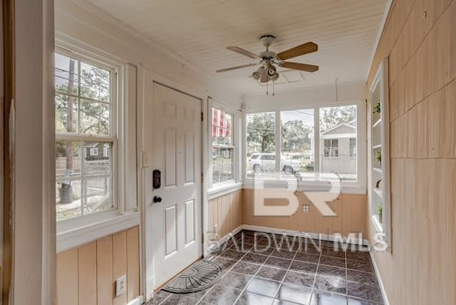 unfurnished sunroom featuring ceiling fan and a wealth of natural light