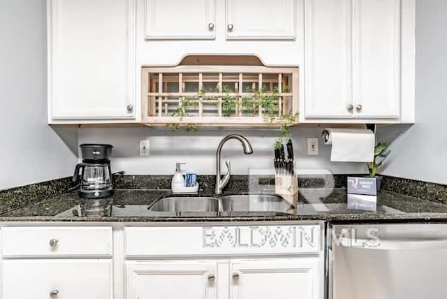 kitchen featuring white cabinetry, stainless steel dishwasher, sink, and dark stone countertops