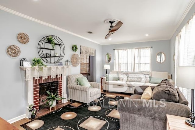 living room with ornamental molding, hardwood / wood-style floors, ceiling fan, and a fireplace