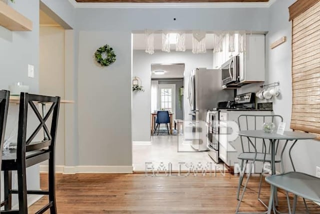 dining room with hardwood / wood-style flooring and crown molding