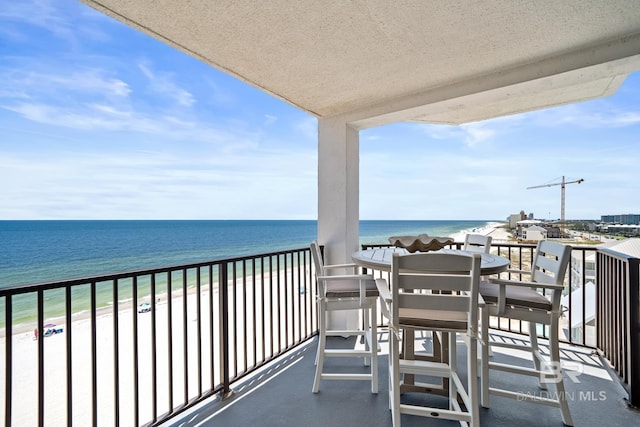 balcony with a water view and a view of the beach