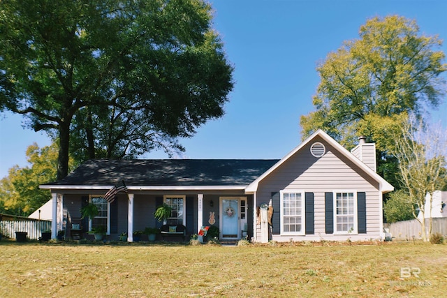 ranch-style home featuring a chimney, a front lawn, and fence