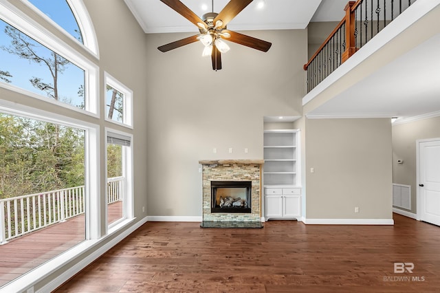 unfurnished living room with a fireplace, baseboards, visible vents, and dark wood-style flooring