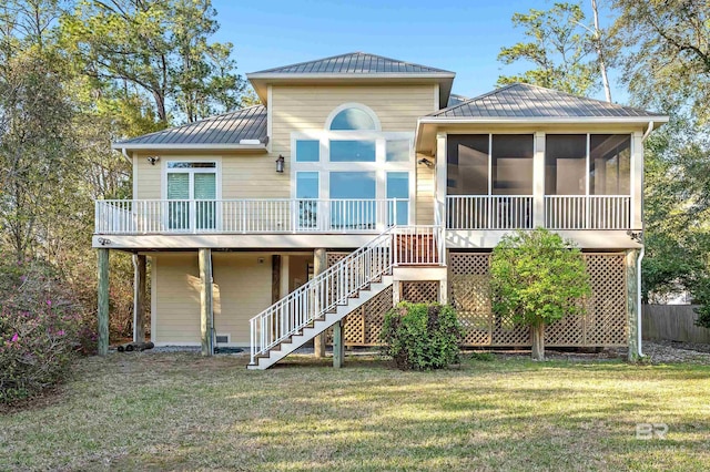 back of property featuring a standing seam roof, a yard, stairway, a sunroom, and metal roof