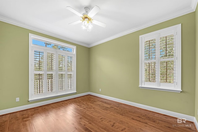 spare room with baseboards, wood finished floors, and ornamental molding