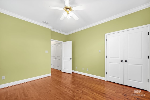 unfurnished bedroom with visible vents, baseboards, and wood finished floors