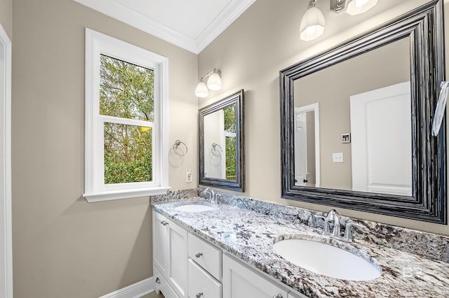 bathroom featuring double vanity, ornamental molding, baseboards, and a sink