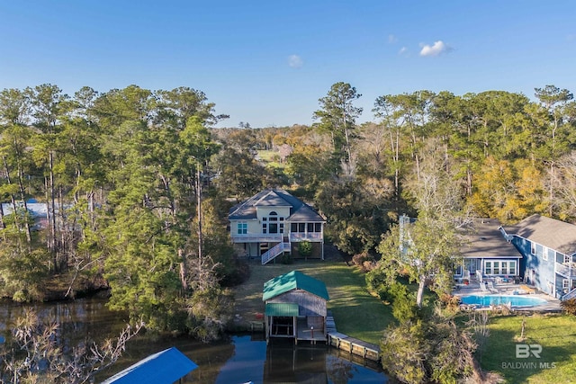 birds eye view of property with a forest view and a water view