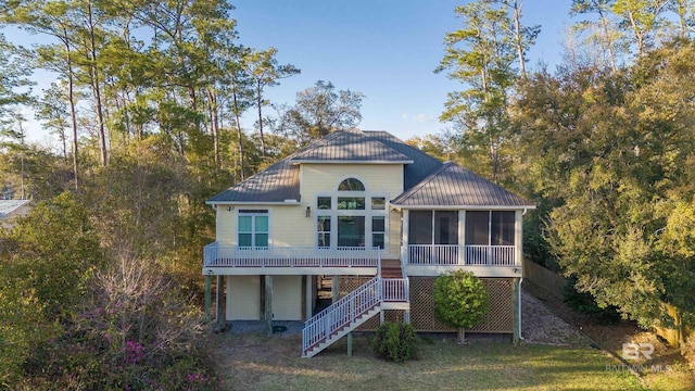 rear view of property with metal roof, stairs, a standing seam roof, and a sunroom