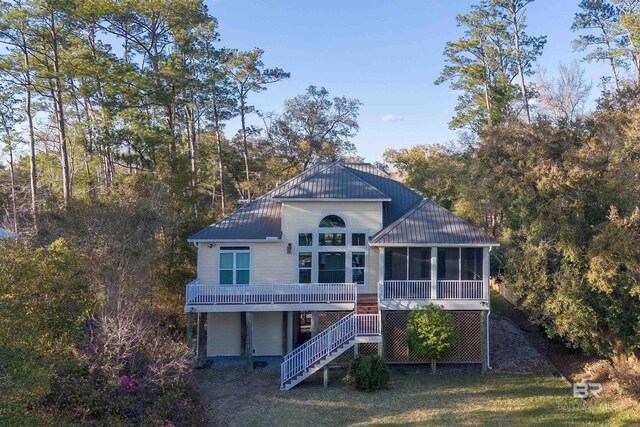 back of house with metal roof, stairs, and a sunroom