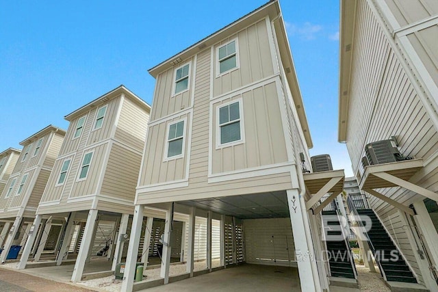 951 W Lagoon Ave, Gulf Shores, AL 36542 - view of property exterior with board and batten siding, a carport, and stairs