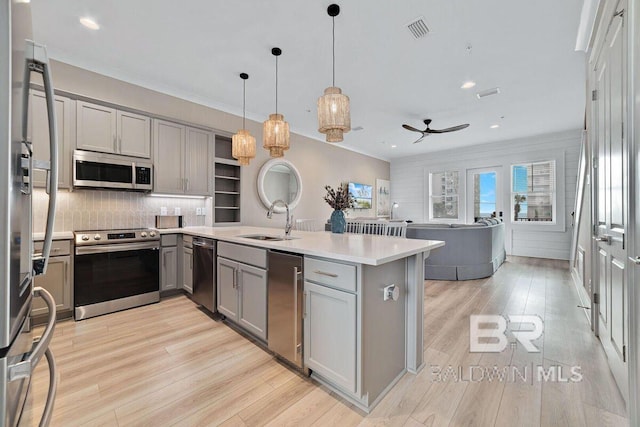 951 W Lagoon Ave, Gulf Shores, AL 36542 - kitchen featuring gray cabinets, appliances with stainless steel finishes, ceiling fan, a peninsula, and backsplash