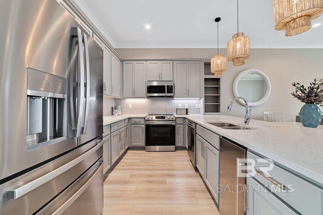 951 W Lagoon Ave, Gulf Shores, AL 36542 - kitchen featuring appliances with stainless steel finishes, gray cabinetry, crown molding, light wood finished floors, and hanging light fixtures