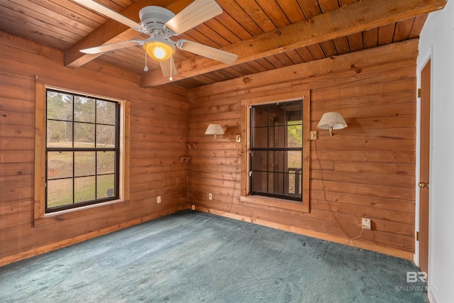 carpeted spare room featuring wood walls, plenty of natural light, beam ceiling, and wooden ceiling