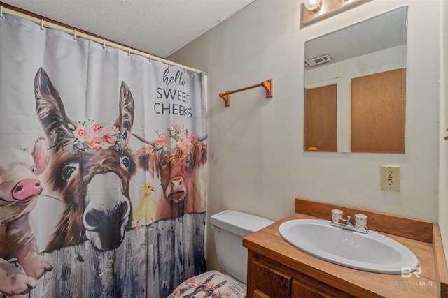 bathroom featuring vanity, toilet, curtained shower, and a textured ceiling