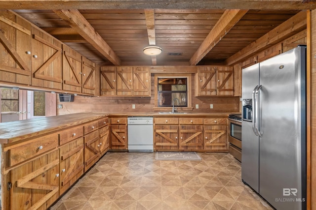 kitchen with wood ceiling, appliances with stainless steel finishes, sink, and wood walls