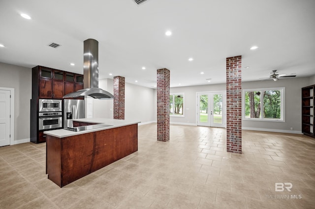 15031 Timber Ridge Dr, Loxley, AL 36551 - kitchen featuring ornate columns, appliances with stainless steel finishes, island exhaust hood, and baseboards