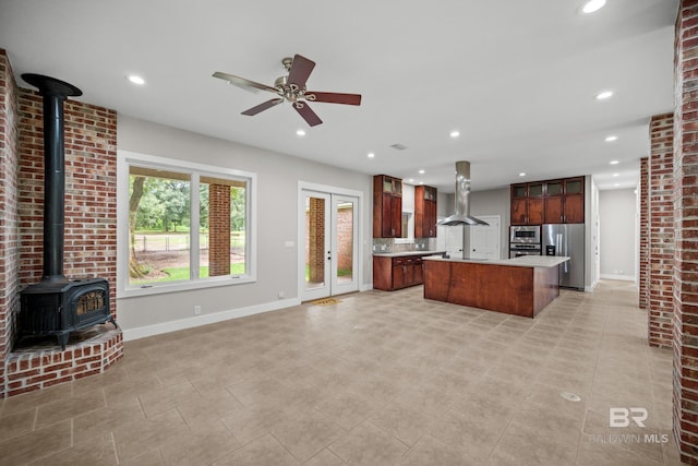 15031 Timber Ridge Dr, Loxley, AL 36551 - kitchen featuring range hood, a wood stove, light countertops, stainless steel appliances, and baseboards