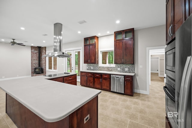 15031 Timber Ridge Dr, Loxley, AL 36551 - kitchen with a wood stove, visible vents, light countertops, stainless steel appliances, and island range hood