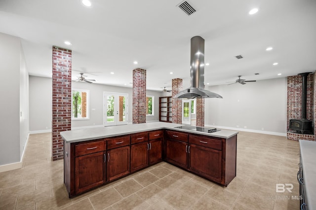 15031 Timber Ridge Dr, Loxley, AL 36551 - kitchen with a wood stove, ceiling fan, visible vents, and island range hood
