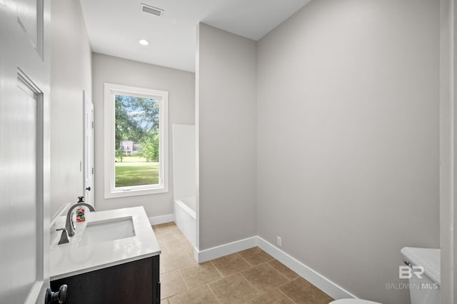 15031 Timber Ridge Dr, Loxley, AL 36551 - bathroom with visible vents, baseboards, toilet, a tub to relax in, and vanity