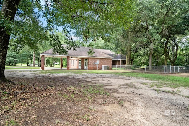 15031 Timber Ridge Dr, Loxley, AL 36551 - view of front of house with central AC, fence, an attached carport, and driveway