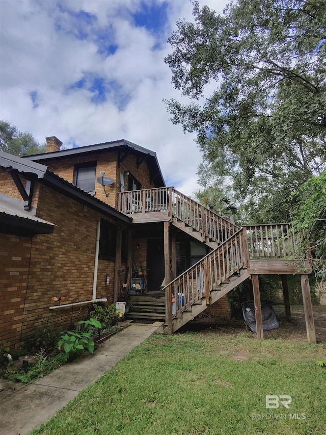 531 W Laurel Ave, Foley, AL 36535 - back of house featuring brick siding, a lawn, a chimney, a deck, and stairs