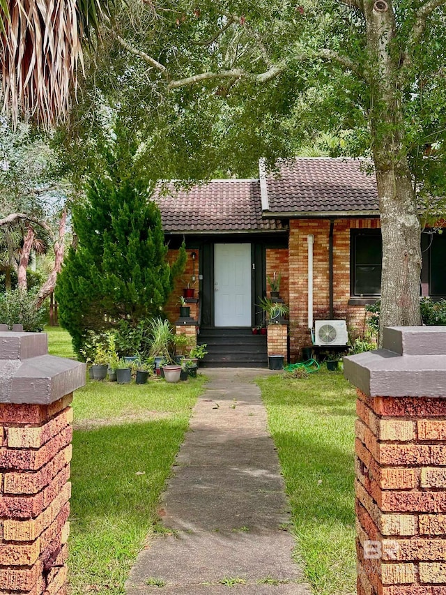 531 W Laurel Ave, Foley, AL 36535 - view of front of house featuring a front yard, a tile roof, ac unit, and brick siding