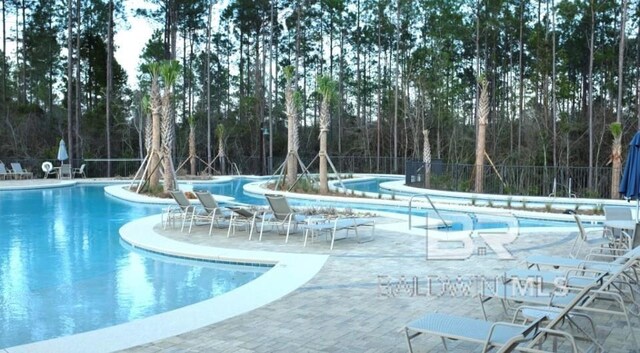 community pool featuring a patio and fence