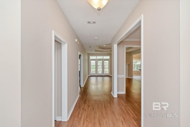 corridor with french doors and light hardwood / wood-style flooring