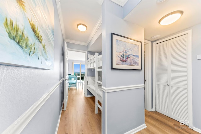 hallway featuring crown molding and light hardwood / wood-style flooring