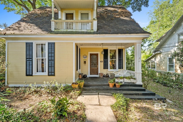 view of front of property featuring a porch and a balcony