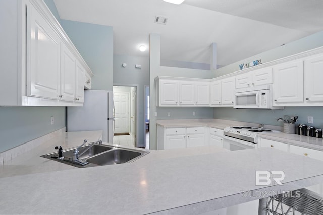 kitchen featuring visible vents, a sink, white appliances, white cabinets, and light countertops