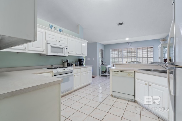 kitchen with visible vents, light countertops, light tile patterned floors, white appliances, and white cabinetry