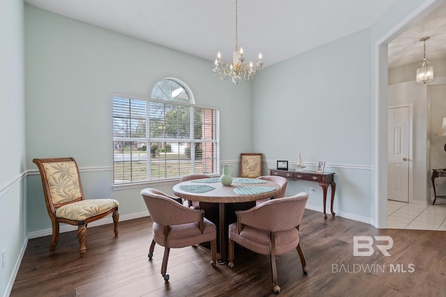 dining room with baseboards, an inviting chandelier, and wood finished floors