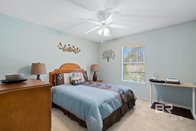 bedroom featuring baseboards, light carpet, a textured ceiling, and ceiling fan