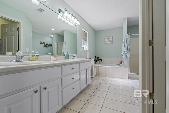 bathroom featuring a sink, visible vents, a bath, and tile patterned floors