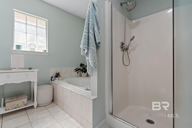 full bathroom with tile patterned flooring, a shower stall, and a garden tub