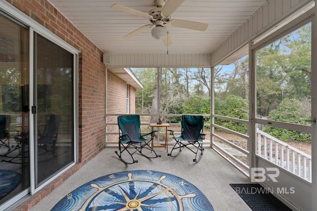 unfurnished sunroom featuring a ceiling fan