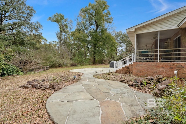 view of yard with ceiling fan and a sunroom