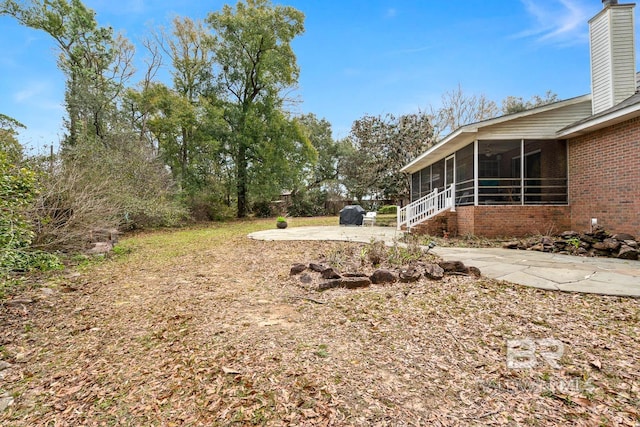 view of yard featuring a patio and a sunroom