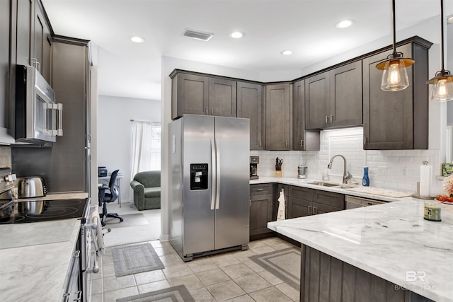 kitchen featuring dark brown cabinets, appliances with stainless steel finishes, a sink, and visible vents