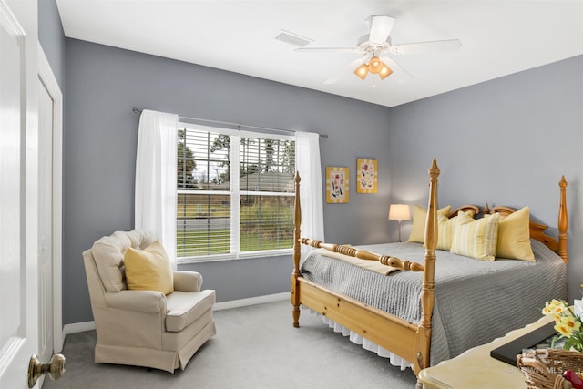 carpeted bedroom featuring a ceiling fan, visible vents, and baseboards