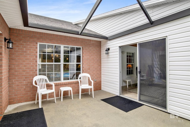 view of patio featuring glass enclosure